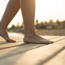 Detail of female barefoot feet on sunny beach
